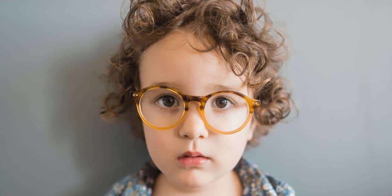Como muitas vezes é diagnosticada na infância, a imagem traz uma criança por volta de 6 anos usando um par de óculos.