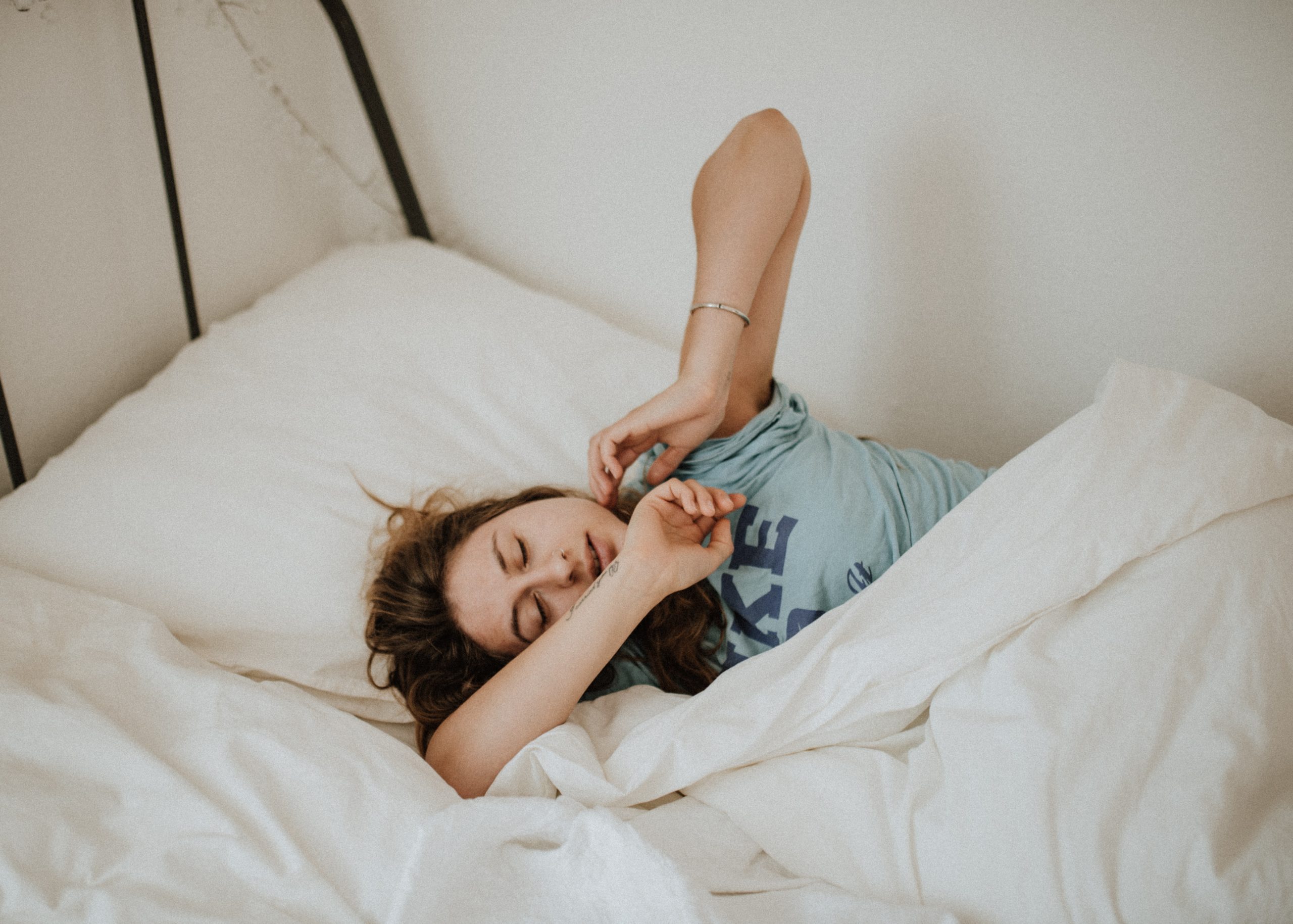 uma mulher com insônia deitada em sua cama tentando dormir