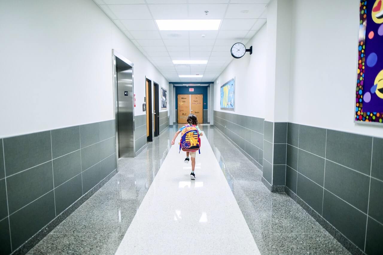 fotografia de criança andando sozinha na escola para simbolizar hiperatividade