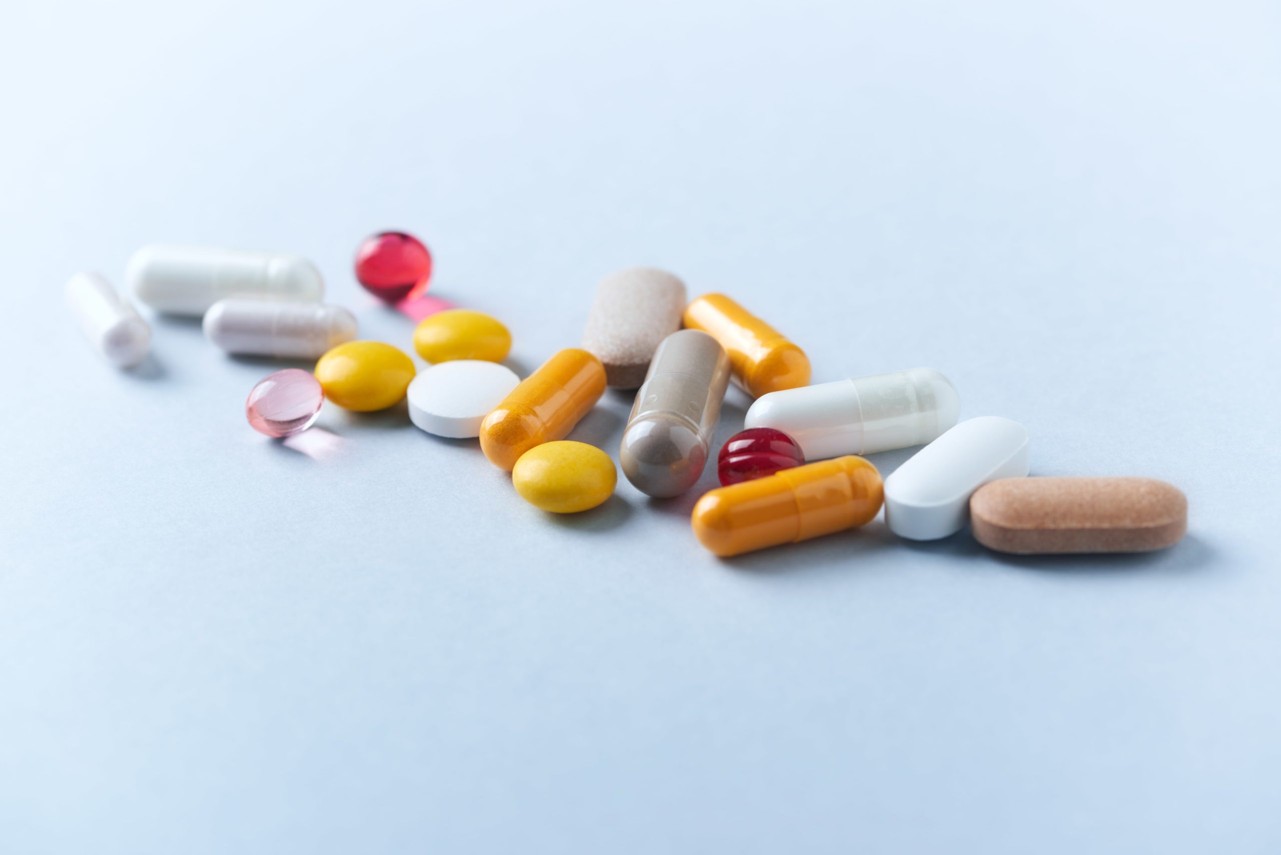 Diversas cápsulas e pílulas de remédios amontoados em uma pilha