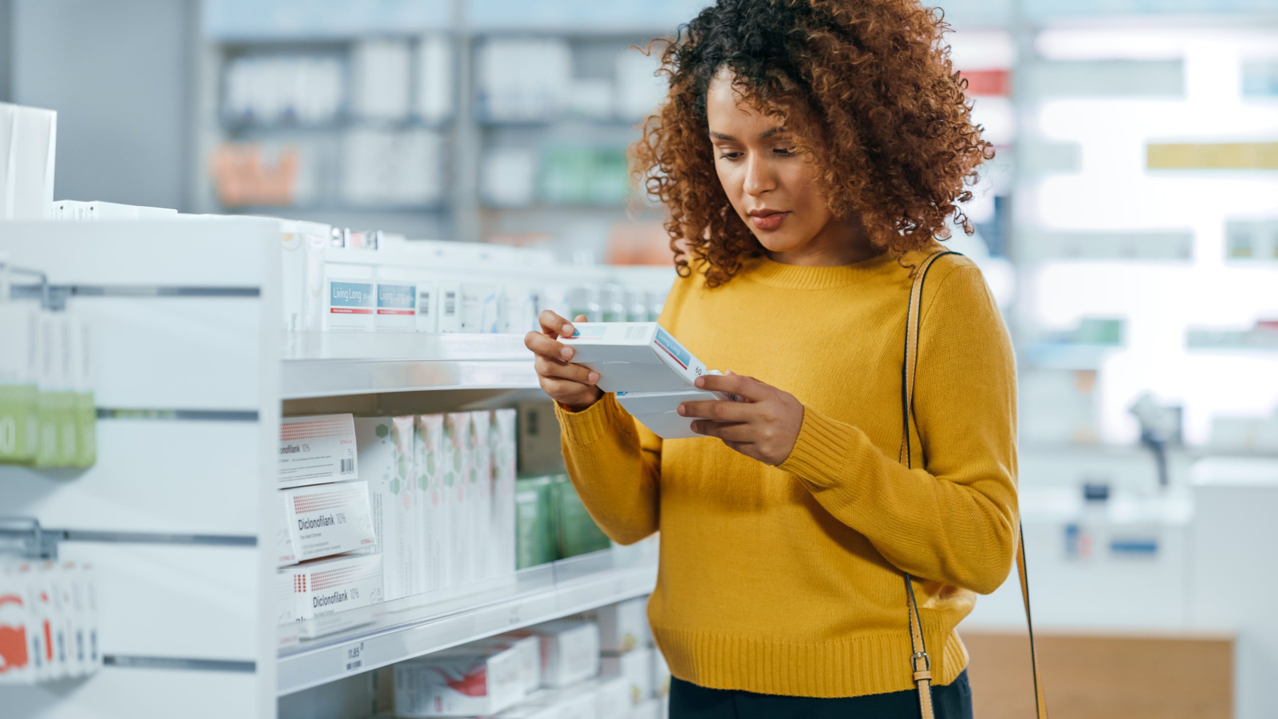 mulher em uma farmácia olhando para um medicamento